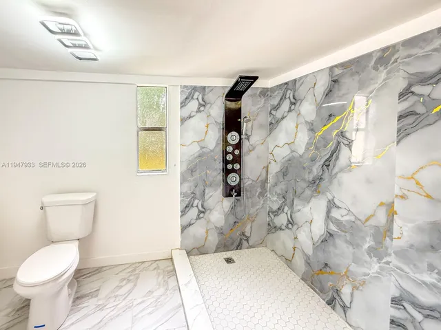 a bathroom with a toilet and a shower