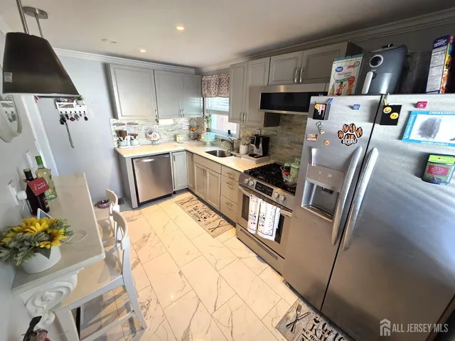 a kitchen with granite countertop a sink appliances and cabinets