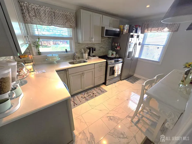 a kitchen with a sink appliances cabinets and a counter top space