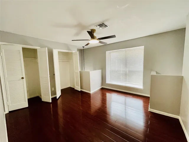 an empty room with wooden floor and window