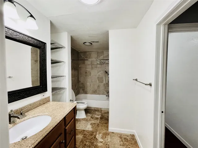 a bathroom with a granite countertop sink a mirror and a bathtub