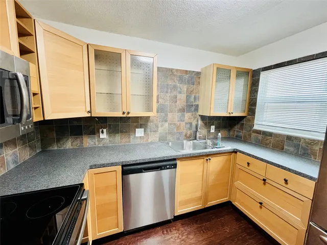 a kitchen with stainless steel appliances granite countertop a sink and a stove