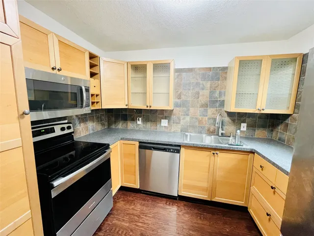 a kitchen with stainless steel appliances a stove a sink and a microwave