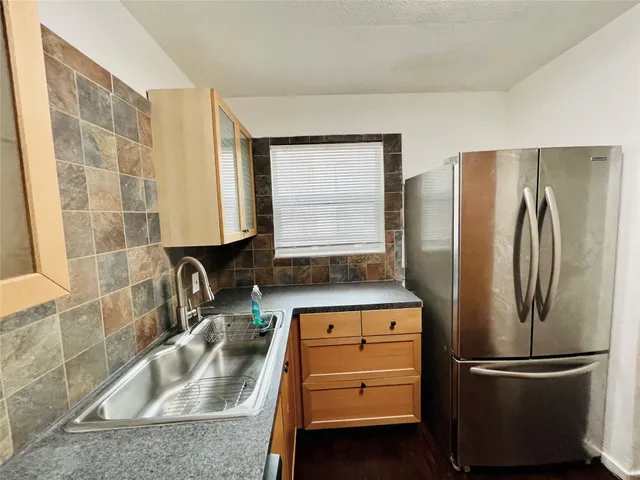 a kitchen with stainless steel appliances granite countertop a refrigerator and a sink
