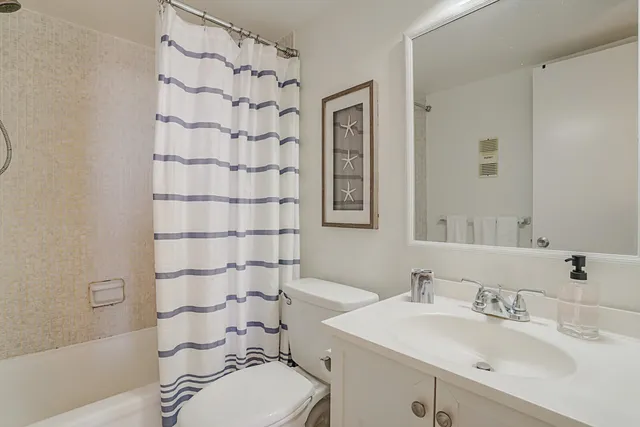 a bathroom with a sink toilet vanity and shower