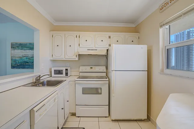 a kitchen with a refrigerator sink stove and cabinets