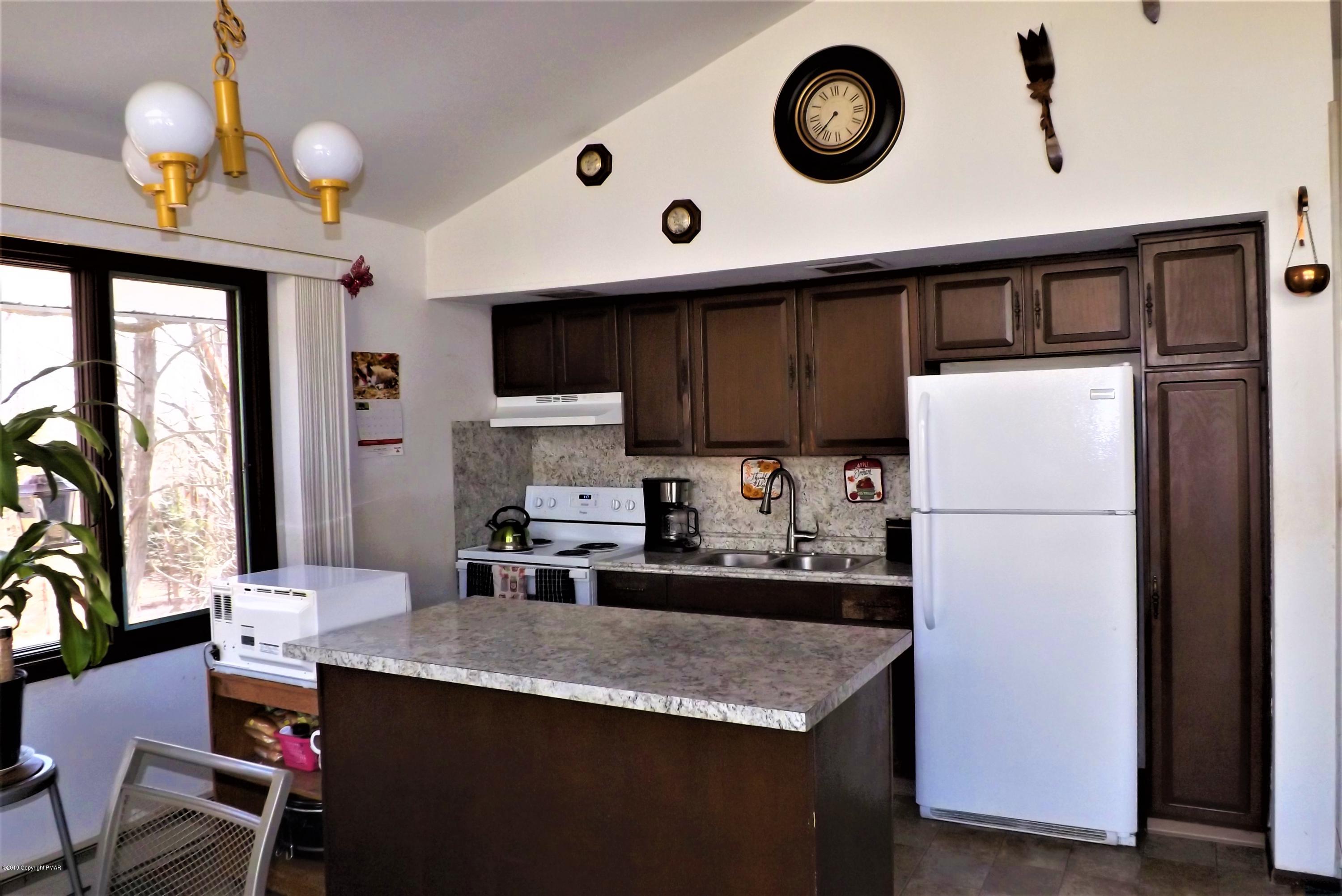 122 Maple Road Blakeslee, PA 18610 - Photo 7 of 37 a kitchen with granite countertop a table chairs stove and cabinets
