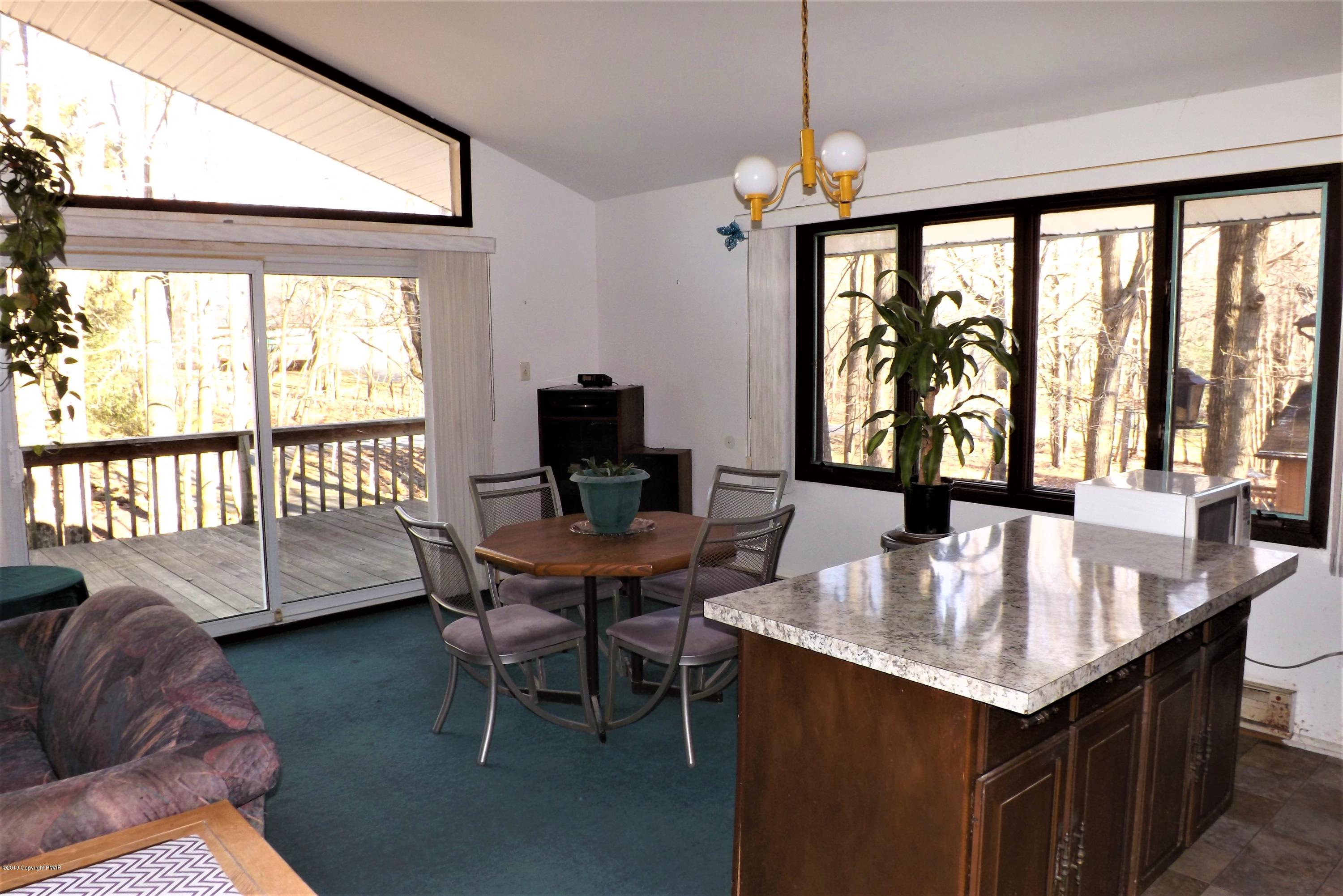 122 Maple Road Blakeslee, PA 18610 - Photo 8 of 37 a dining room with furniture a chandelier and wooden floor
