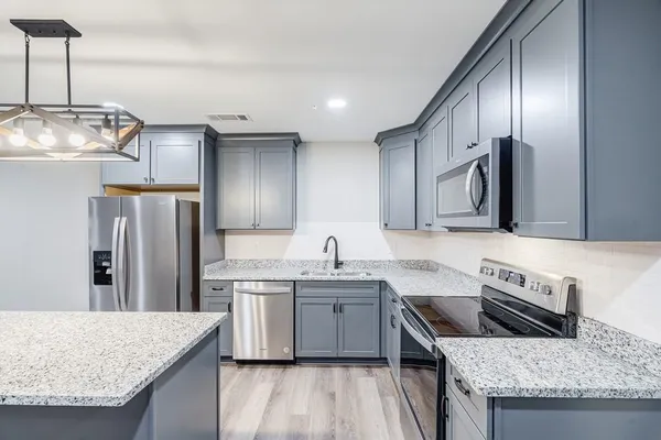 a kitchen with granite countertop a sink and stainless steel appliances
