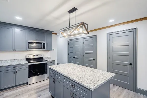 a kitchen with granite countertop stainless steel appliances and white cabinets