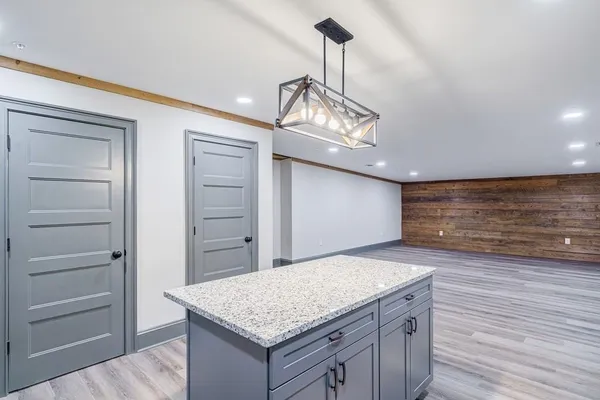 an empty room with wooden floor chandelier fan and window