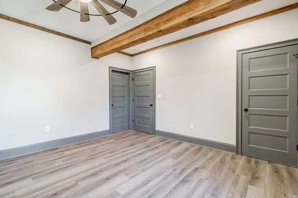 a view of a hallway with wooden floor and closet