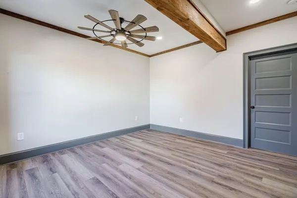 a view of a hallway with wooden floor and a chandelier