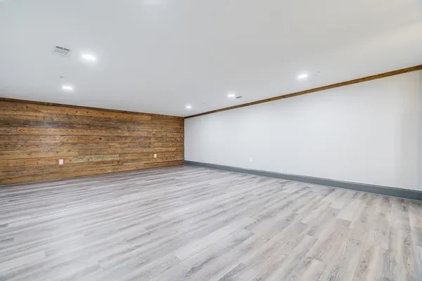 a view of an empty room with wooden floor