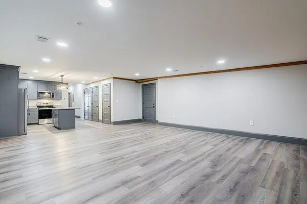 a view of empty room with wooden floor
