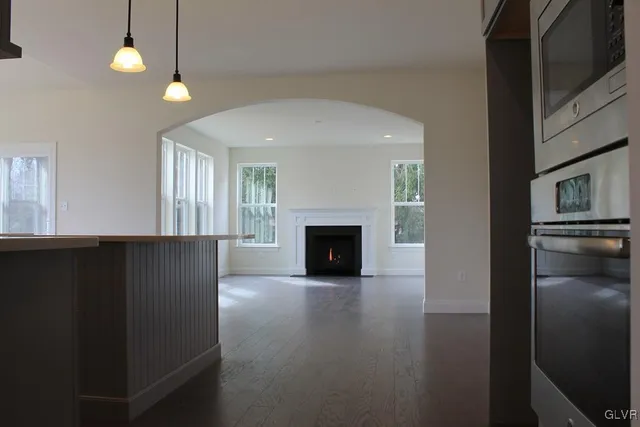 an empty room with windows and fireplace