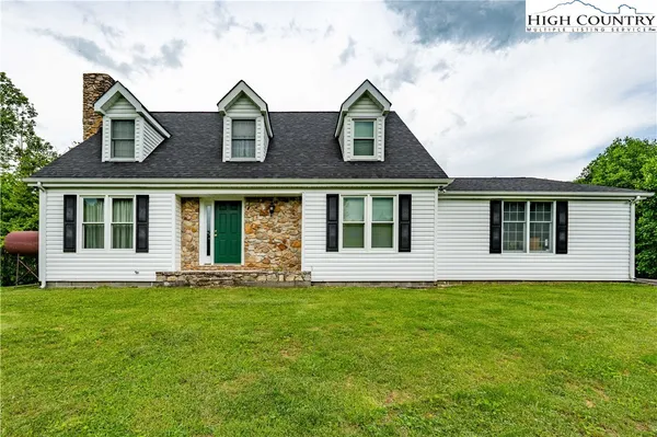 a view of a house with a yard and deck