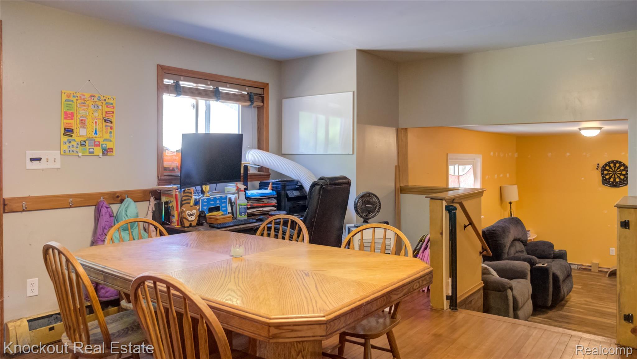 4195 Williamson Road Saginaw, MI 48601 - Photo 14 of 50 Octagonal wood-finish table in a room featuring wood-trim windows, wood-finish flooring, and a partial wall with a wood railing