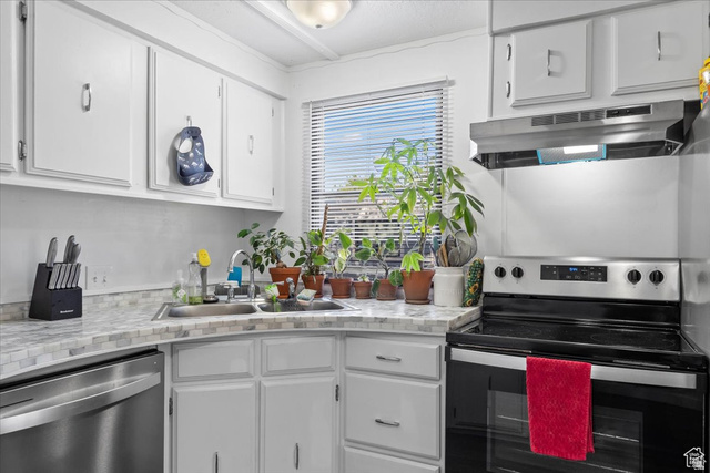 2875 North Hill Field Road, Unit 17 Layton, UT 84041 - Photo 5 of 23 Kitchen with stainless steel appliances, white cabinetry, under cabinet range hood, and light stone countertops