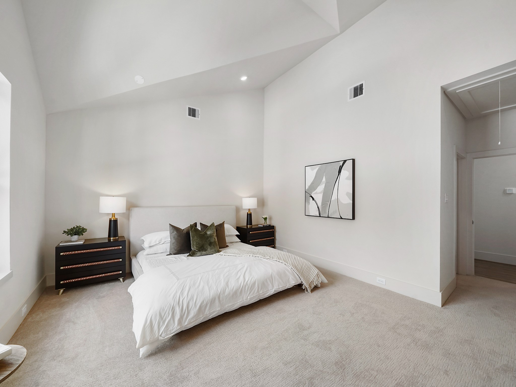 861 Rachel Street, Unit E Houston, TX 77091 - Photo 11 of 29 This primary suite offers a spacious retreat with high ceilings and abundant natural light, creating an airy and inviting atmosphere.