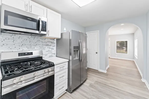 a kitchen with stainless steel appliances kitchen island wooden cabinets and a stove top oven