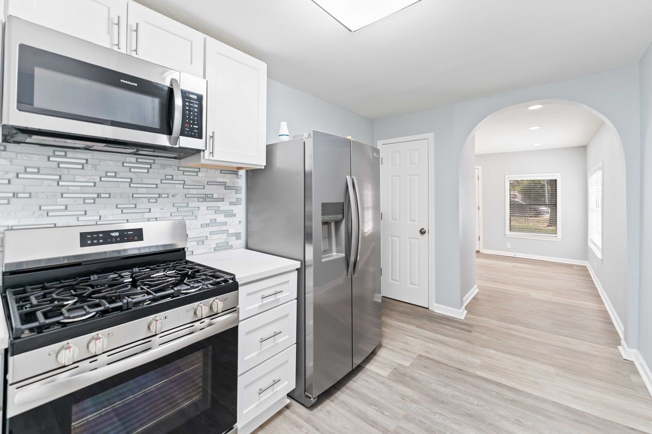 a kitchen with stainless steel appliances kitchen island wooden cabinets and a stove top oven