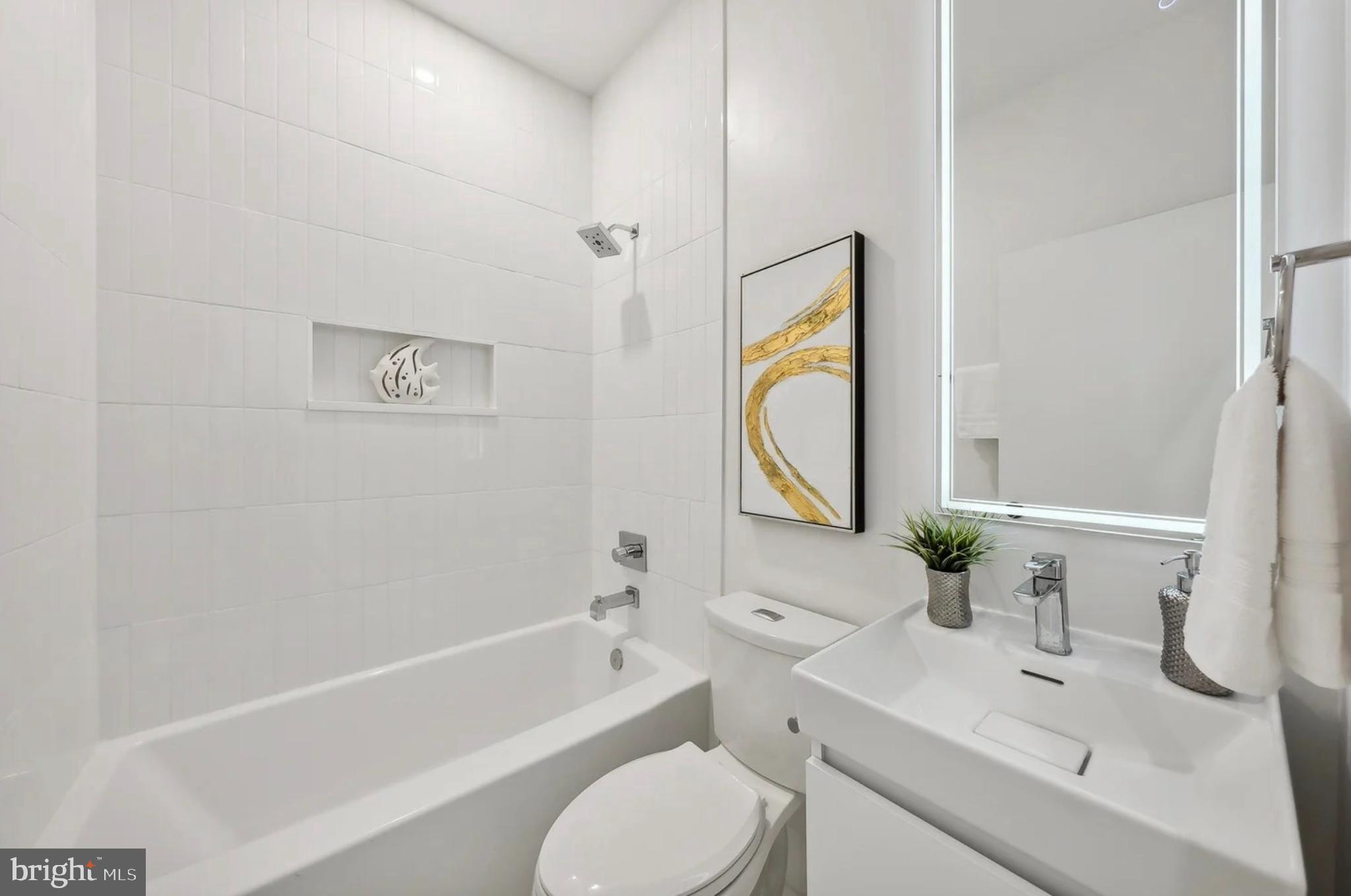 2015 13th Street Northwest, Unit 2 Washington, DC 20009 - Photo 21 of 40 a bathroom with a granite countertop sink toilet a mirror and bathtub