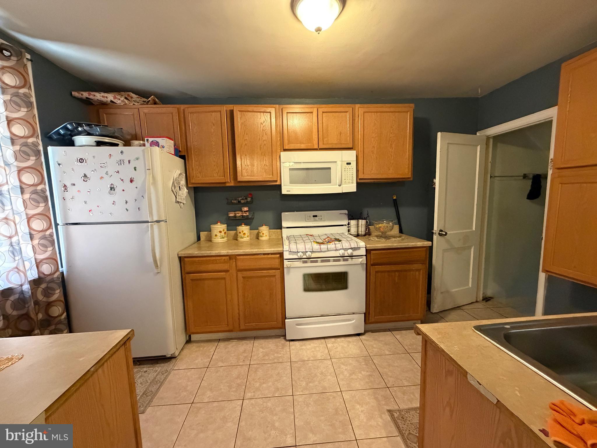4317 Chippendale Street Philadelphia, PA 19136 - Photo 5 of 11 a kitchen with a refrigerator sink stove and cabinets