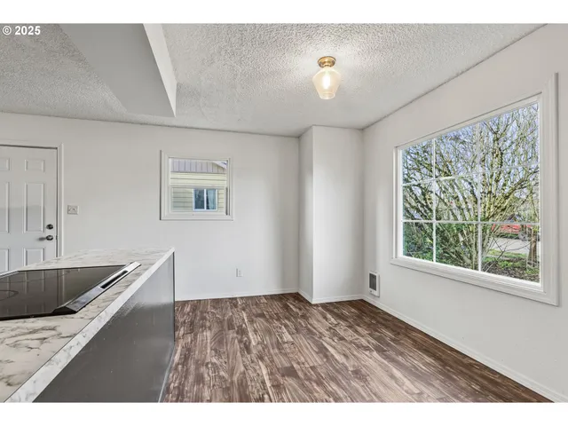 a view of kitchen and hall with wooden floor