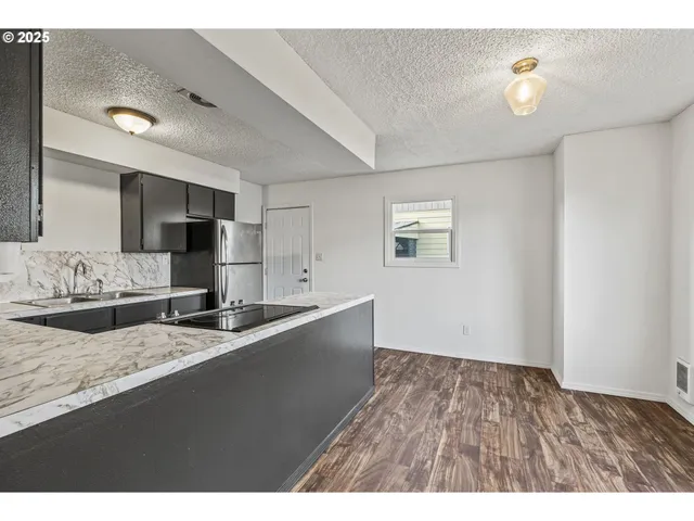 a kitchen with granite countertop a sink stainless steel appliances and cabinets