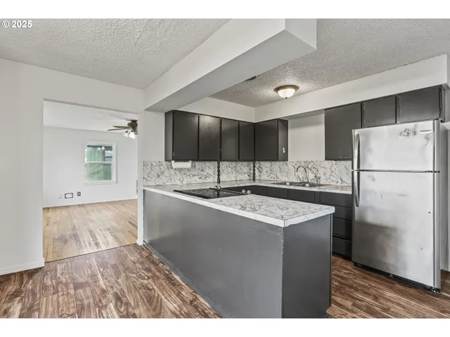 a kitchen with refrigerator and cabinets