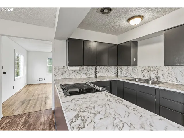 a kitchen with granite countertop a sink and cabinets