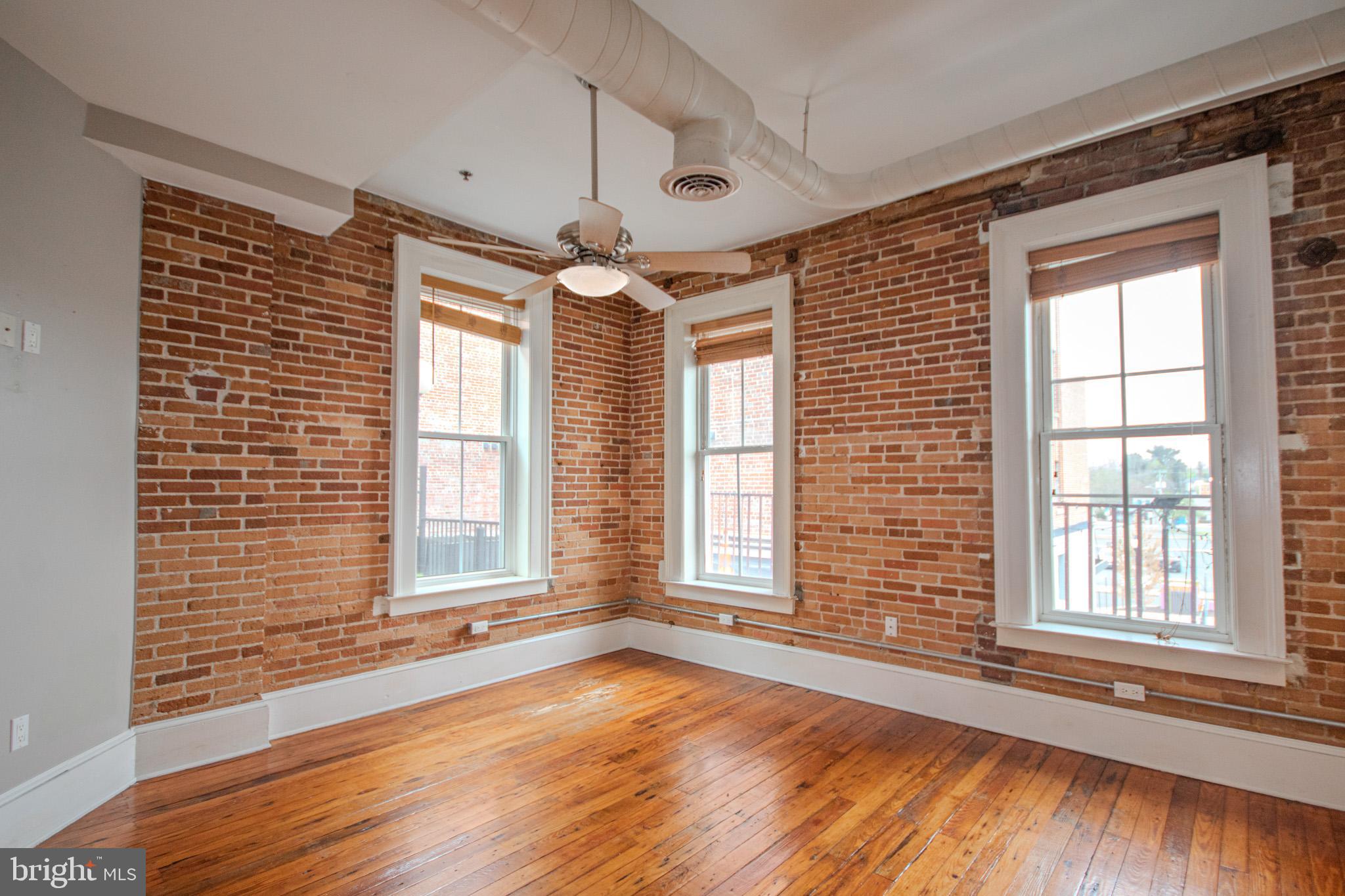 224 West Main Street, Unit 203 Salisbury, MD 21801 - Photo 11 of 20 a view of an empty room with a window and wooden floor