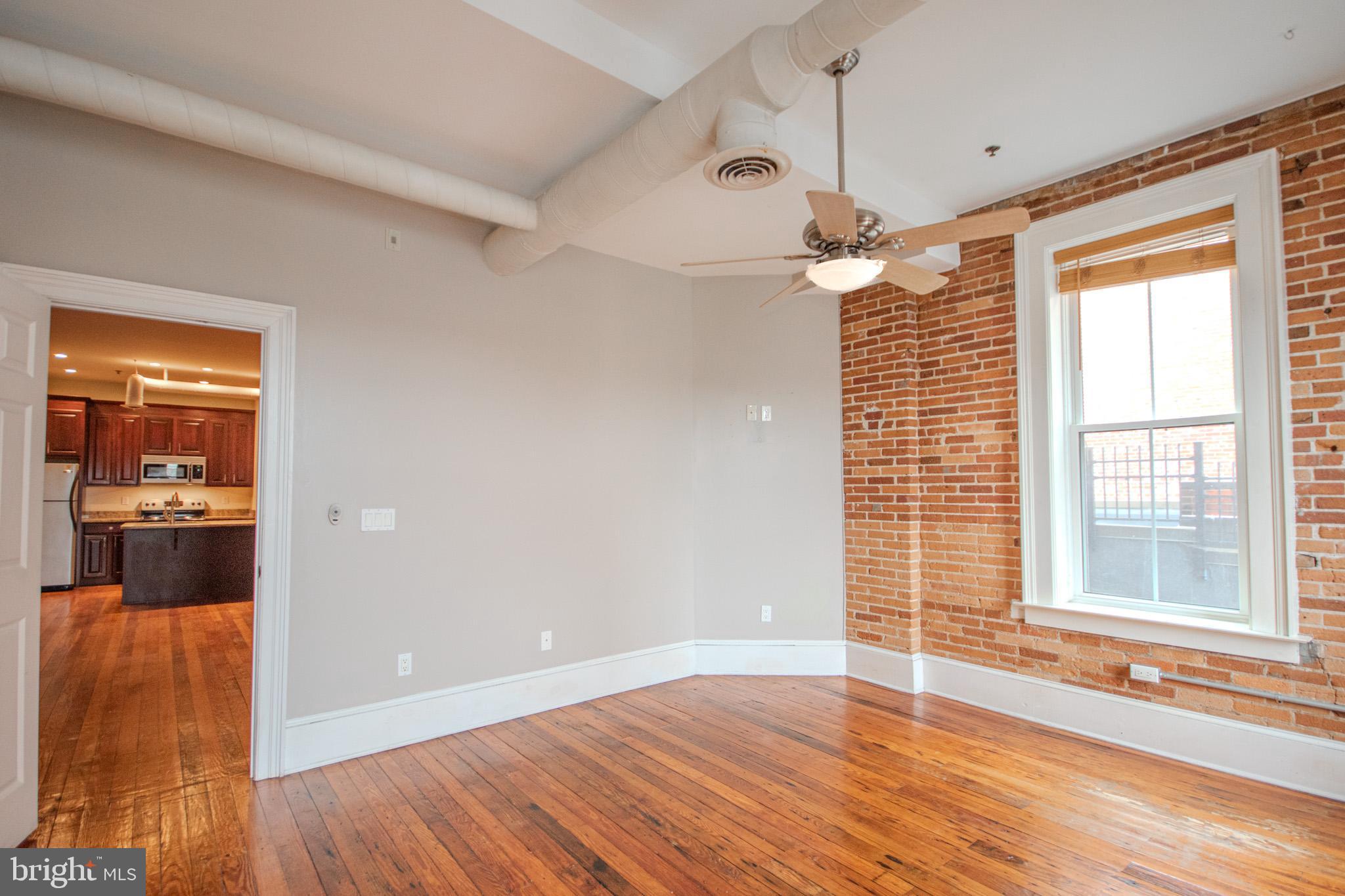 224 West Main Street, Unit 203 Salisbury, MD 21801 - Photo 12 of 20 a view of an empty room with a window and wooden floor