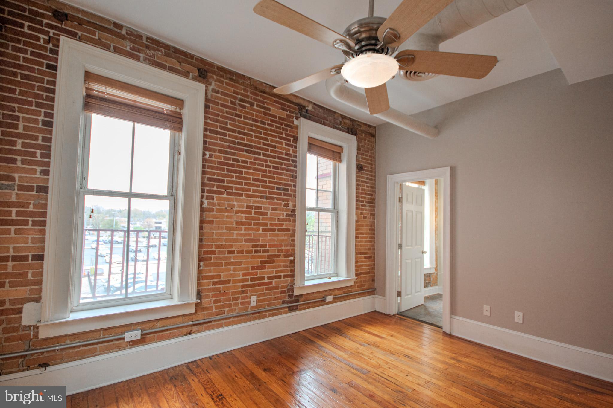 224 West Main Street, Unit 203 Salisbury, MD 21801 - Photo 14 of 20 a view of an empty room with wooden floor and a window