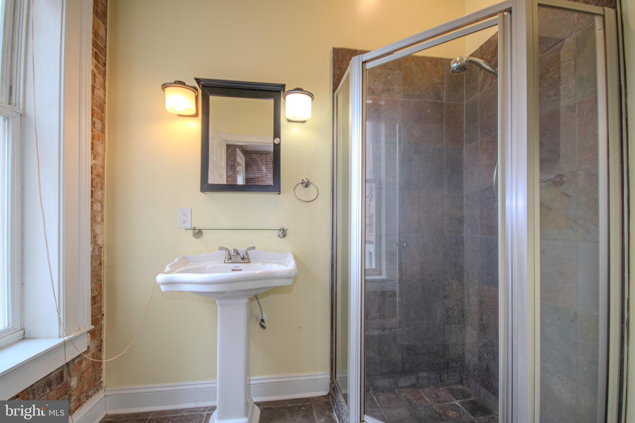 224 West Main Street, Unit 203 Salisbury, MD 21801 - Photo 15 of 20 a bathroom with a sink mirror and shower