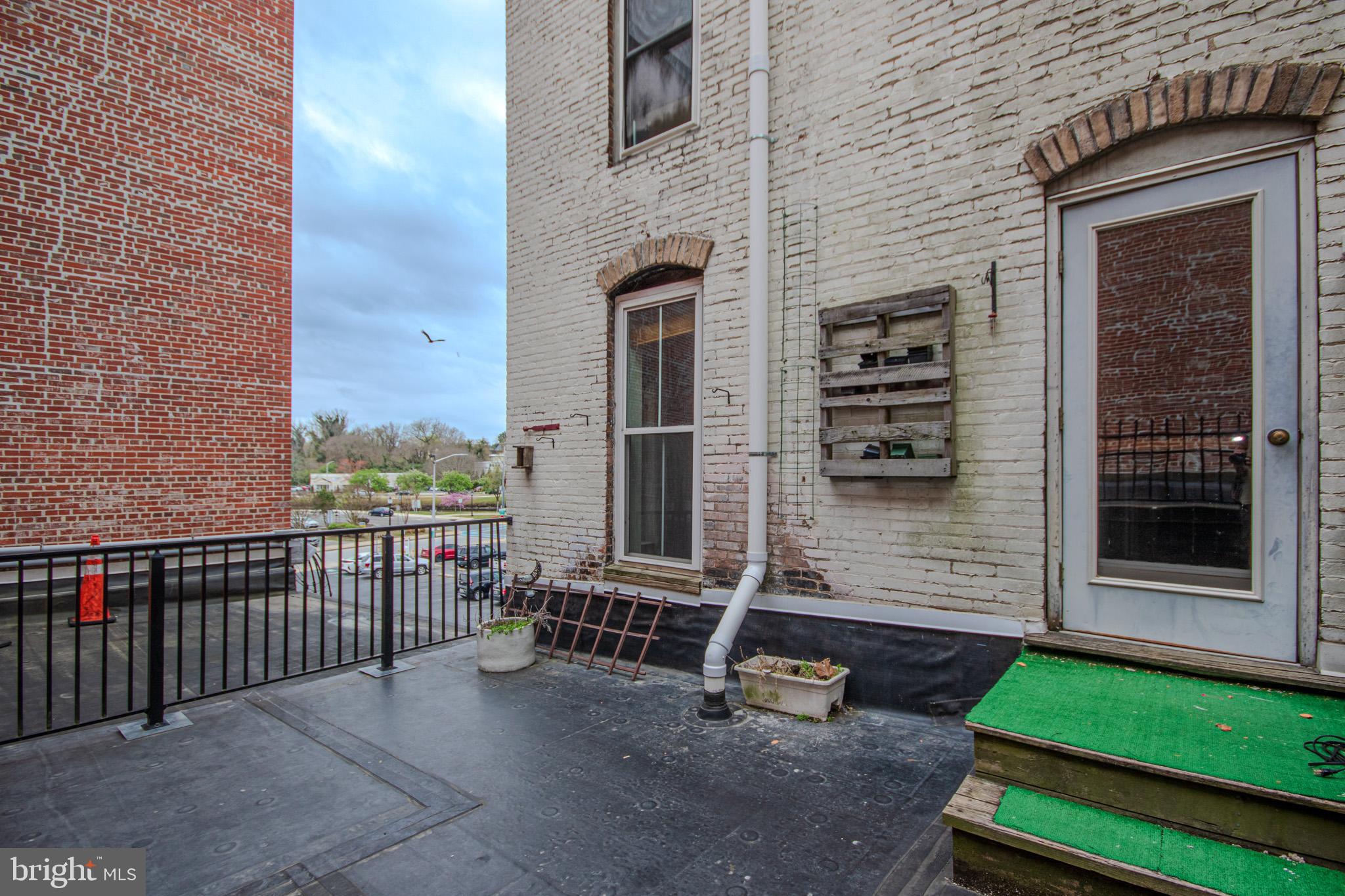 224 West Main Street, Unit 203 Salisbury, MD 21801 - Photo 17 of 20 a view of a porch with chairs and a yard