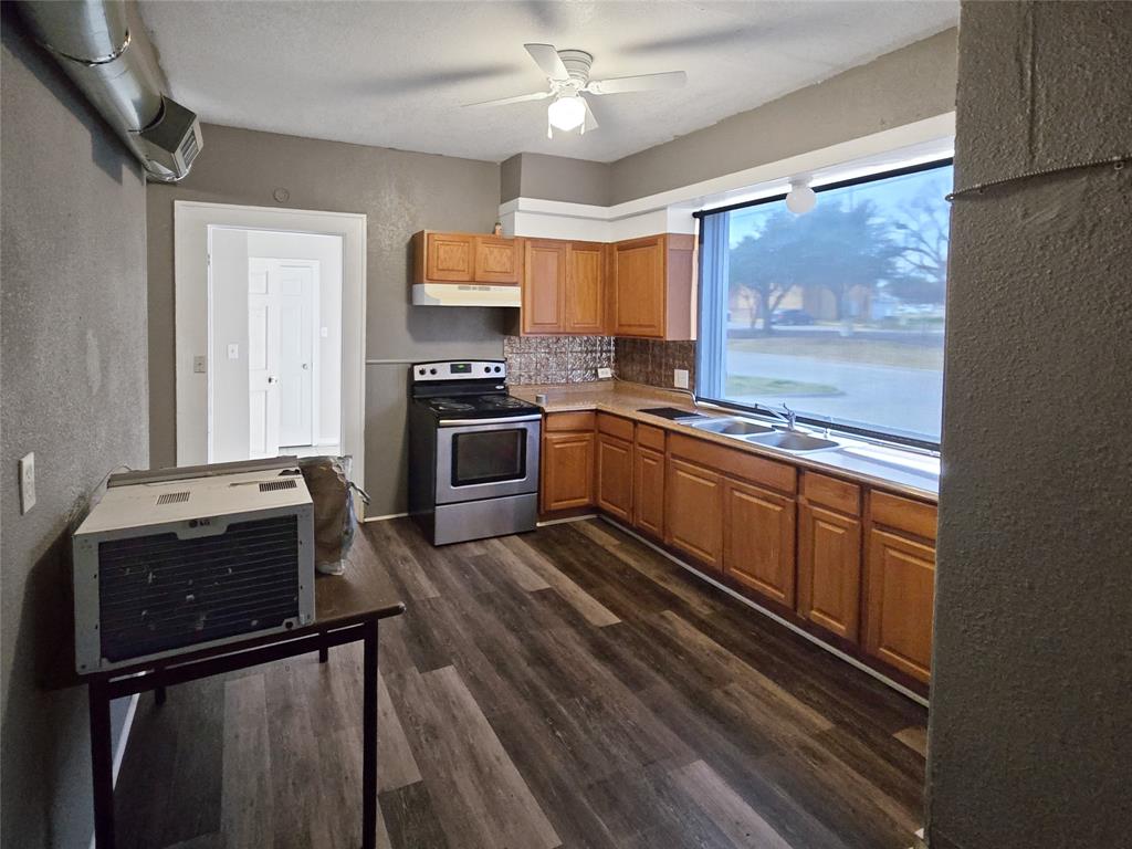 507 West Nash Street Terrell, TX 75160 - Photo 20 of 22 a kitchen with granite countertop stainless steel appliances and wooden cabinets