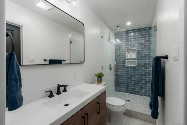 a bathroom with a sink a toilet and shower