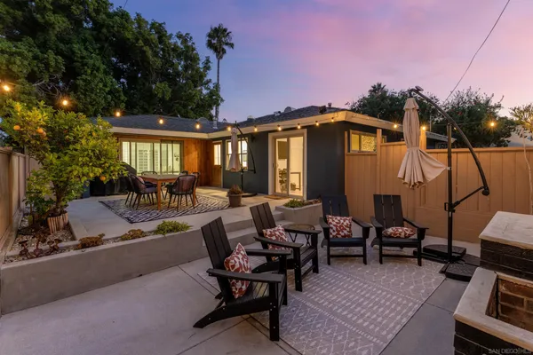 a view of a patio with couches table and chairs and potted plants