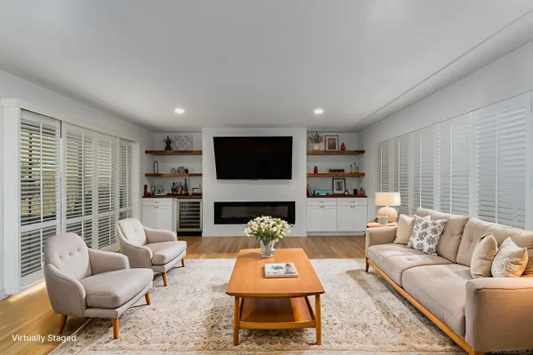 a living room with furniture a flat screen tv and a large window