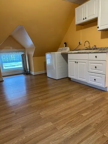 a kitchen with cabinets and wooden floor
