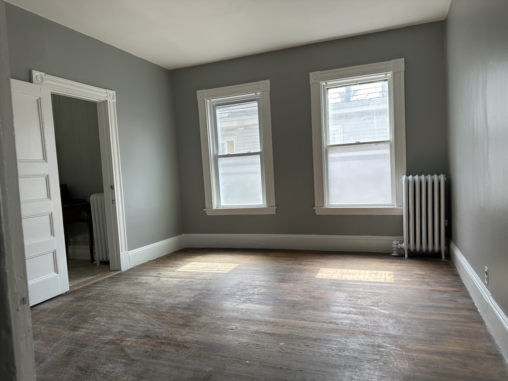 4 Ruthven Street Boston, MA 02121 - Photo 5 of 19 an empty room with wooden floor and windows