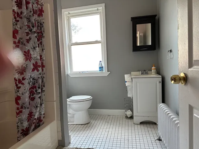 a bathroom with a sink toilet and window