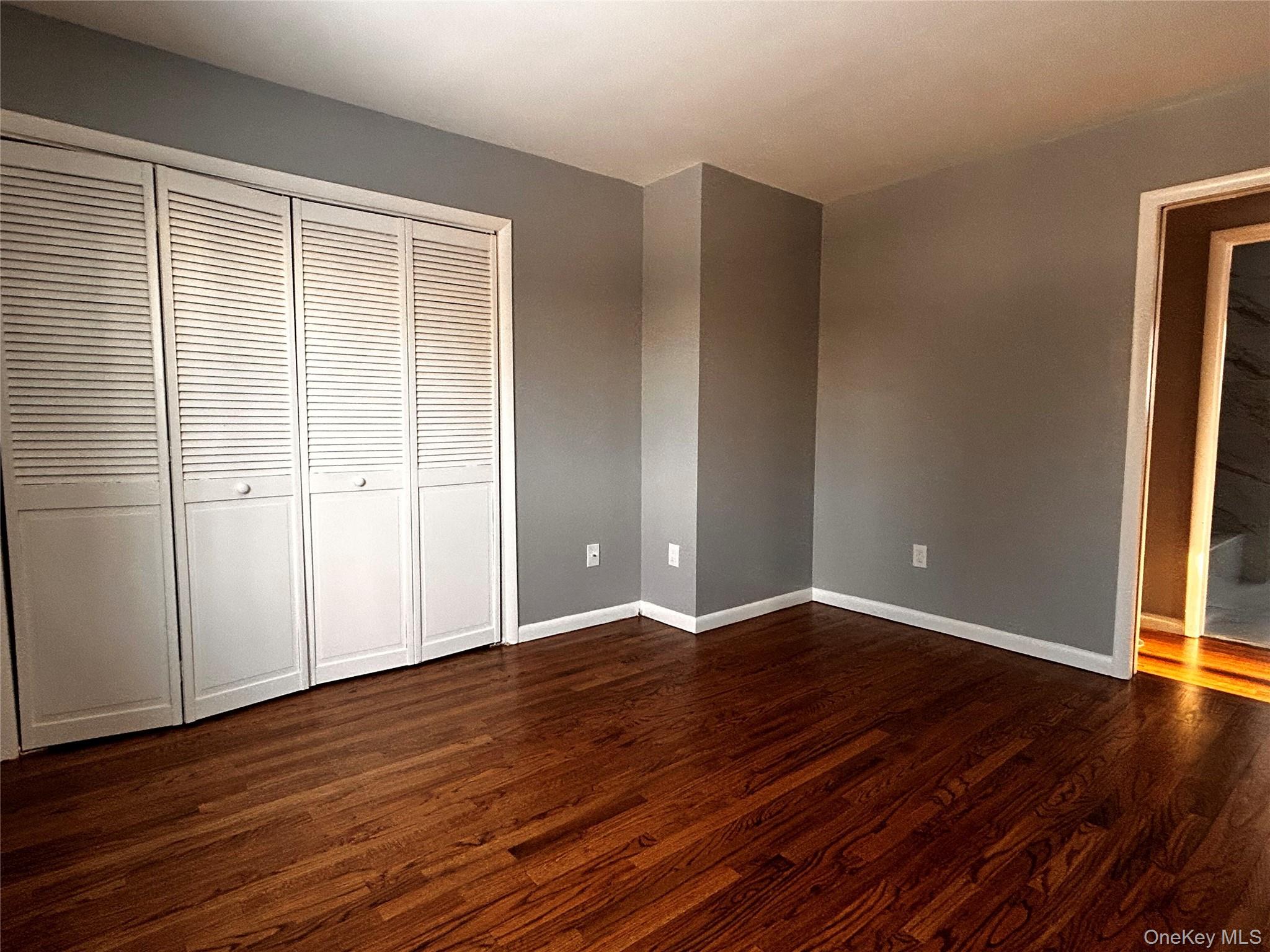 218 Beattie Road Washingtonville, NY 10992 - Photo 12 of 15 Unfurnished bedroom featuring dark wood-style flooring and a closet