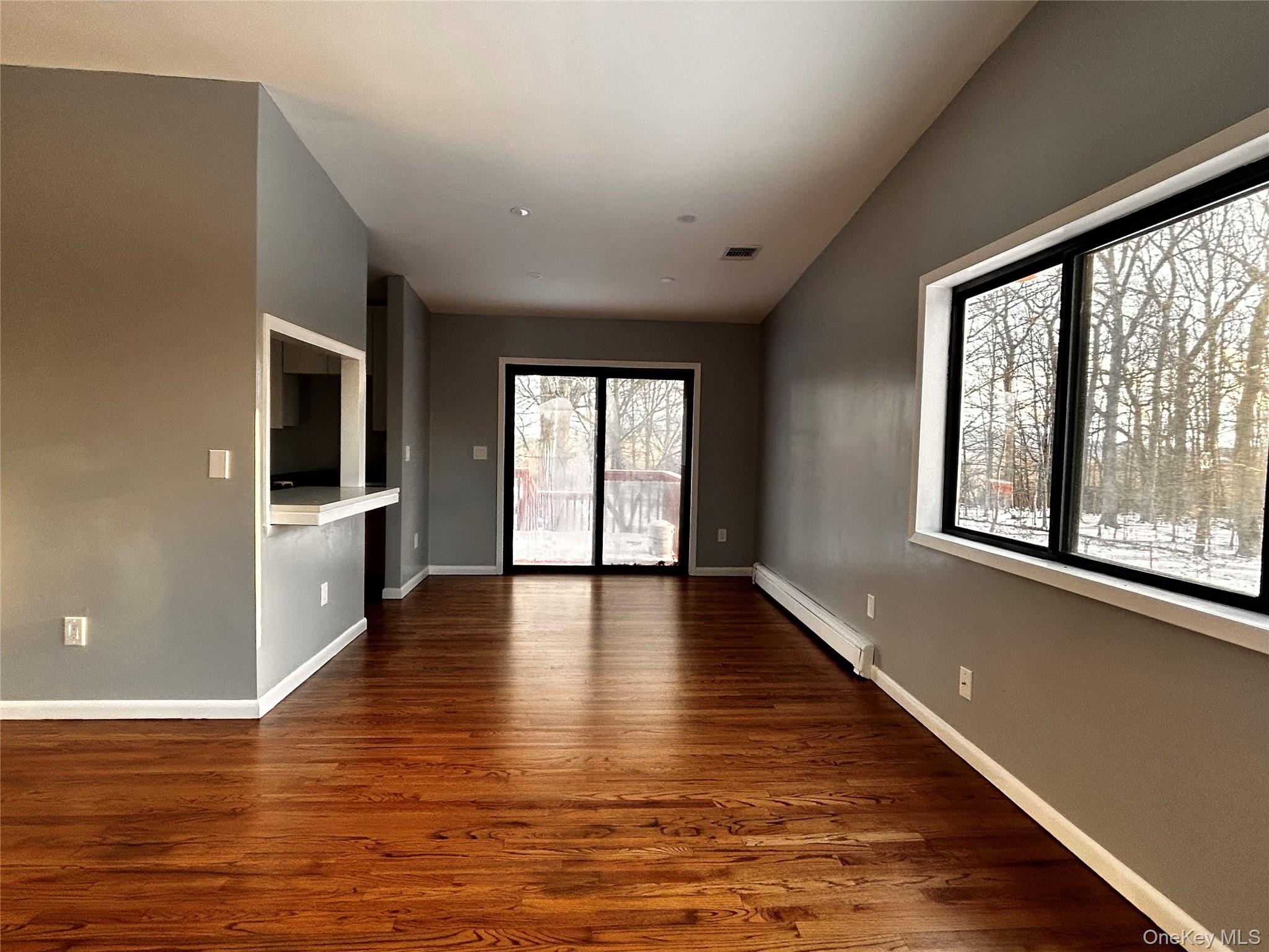 218 Beattie Road Washingtonville, NY 10992 - Photo 4 of 15 Unfurnished living room with a baseboard heating unit and dark wood-type flooring