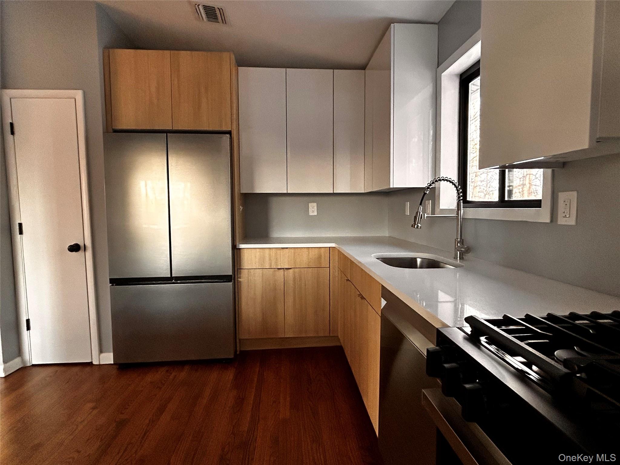 218 Beattie Road Washingtonville, NY 10992 - Photo 7 of 15 Kitchen with freestanding refrigerator, light stone counters, range with gas stovetop, dark wood-style flooring, and modern cabinets