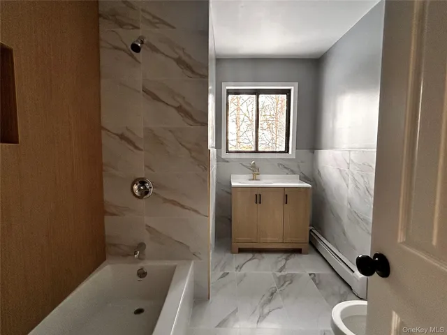 a bathroom with a tub sink and mirror