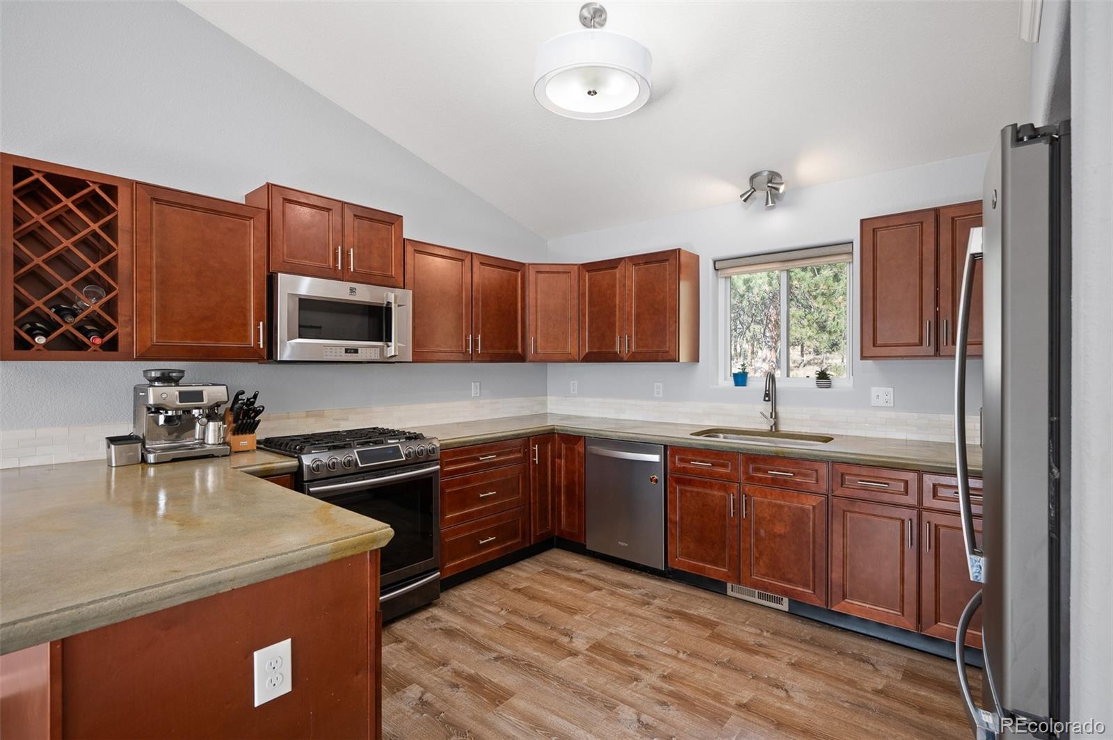 560 Gunsmoke Drive Bailey, CO 80421 - Photo 12 of 43 a kitchen with stainless steel appliances granite countertop wooden cabinets a stove top oven a sink and dishwasher