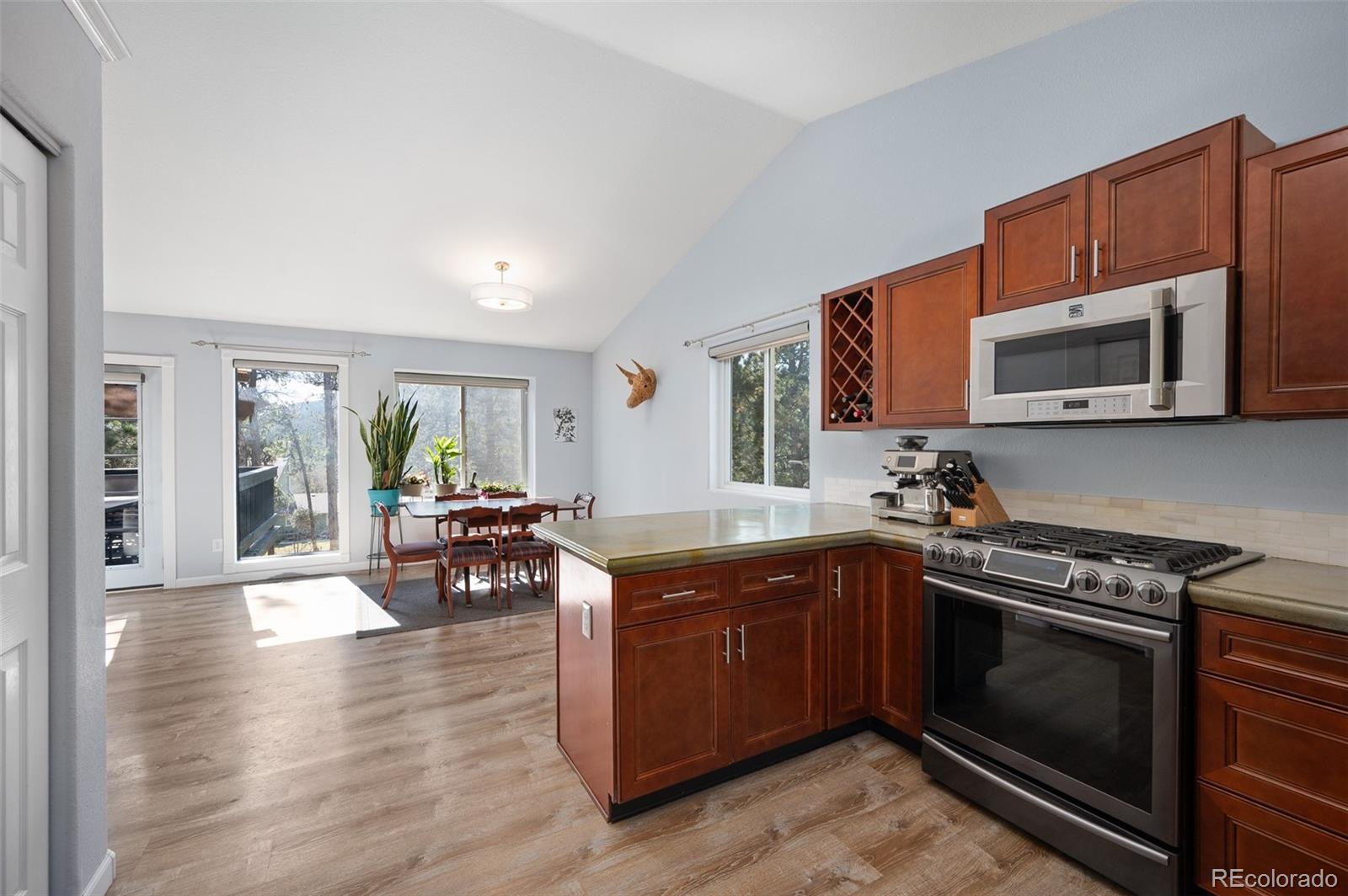 560 Gunsmoke Drive Bailey, CO 80421 - Photo 13 of 43 a kitchen with stainless steel appliances granite countertop a stove top oven microwave and cabinets